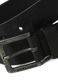Cinturón de cuero negro con un acabado texturizado, con una hebilla rectangular metálica en color plata y detalle de logo grabado.