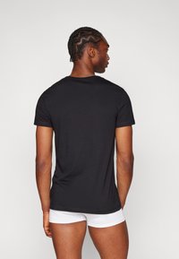 Black short-sleeve t-shirt made of soft fabric, featuring a classic crew neck and a regular fit, displayed from the back.