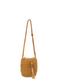 Woven strawowa torba na ramię z teksturowaną powierzchnią, w kolorze beżowym, z długim brązowym skórzanym paskiem oraz akcentem w postaci frędzla z koralików.