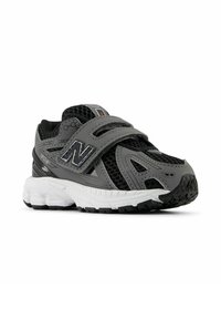 Botte de sport grise avec un dessus en mesh, une sangle Velcro et une semelle blanche rembourrée. Présente un logo sur le côté et une semelle extérieure en caoutchouc texturé.