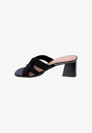 Sandalo mule nero con punta aperta, cinturini incrociati in tessuto e tacco medio spesso su sfondo bianco.