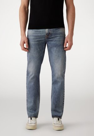 Light blue denim jeans with a straight-leg cut, subtle fading, and a classic five-pocket design. Worn with white sneakers.