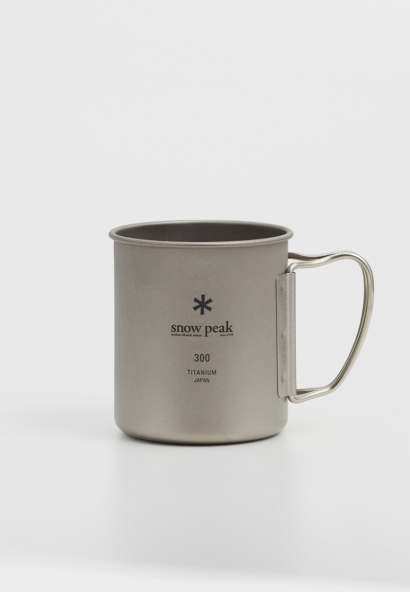 Tazza in titanio con forma cilindrica, finitura argento opaco, manico metallico e logo stampato. Capacità indicata di 300, prodotta in Giappone.