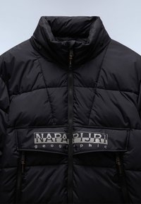 NapaPuri schwarze Steppjacke mit hohem Kragen, gestepptem Design, durchgehendem Reißverschluss und Logopatch auf der Brust. Verfügt über zwei Reißverschlusstaschen.