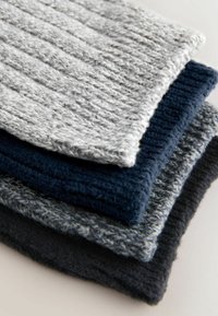 Teksturowana dzianina w różnych odcieniach: jasnoszary, granatowy i ciemnoszary. Każdy element ma prążkowany wzór i miękką fakturę.