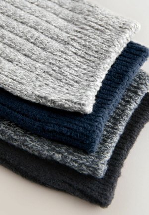 Teksturowana dzianina w różnych odcieniach: jasnoszary, granatowy i ciemnoszary. Każdy element ma prążkowany wzór i miękką fakturę.