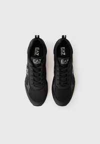 Et par sorte EA7 Emporio Armani sneakers med mesh- og læderdetaljer, snøret op, set ovenfra på en hvid baggrund.