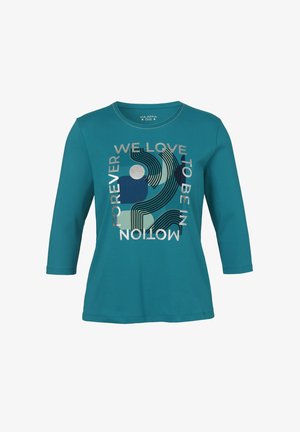 Teal langemouwen shirt met abstracte vormen en tekst die zegt "We houden ervan om voor altijd in beweging te zijn" in zilveren en blauwe opdruk.