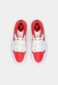 Ζευγάρι λευκών και κόκκινων αθλητικών παπουτσιών Air Jordan, βλέποντας από πάνω, με κορδόνια και λογότυπα Jumpman στις γλώσσες και τις εσωτερικές σόλες.