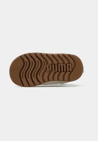Sneaker zool in licht tan rubber met golvenpatroon; bevat het "PUMA" logo prominent in het midden geperst. Vlakke oppervlaktestructuur.