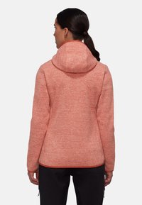 Fleece hoodie i melerad korall med en åtsittande huva. Har en mjuk yta, långa ärmar och en något avsmalnande silhuett vid midjan.