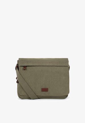 Sac messager en toile vert olive avec bandoulière ajustable et tirette en cuir marron sur le rabat avant.