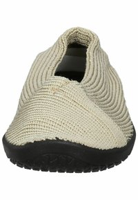 Beige Slipper mit strukturiertem gewebtem Obermaterial, schwarzer Gummisohle und einzigartigem Überkreuzdesign an der Vorderseite für einen bequemen Sitz.