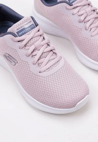 Scarpe da ginnastica Skechers rosa chiaro con tomaia in rete, punta rotonda, design con lacci e suola in gomma bianca. Presenta un logo sul lato.