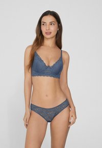 Niebieski koronkowy biustonosz i pasujące stringi z falbaniastymi brzegami i wzorem kwiatowym, z regulowanymi ramiączkami i miękką teksturą.