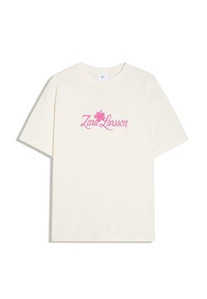 Wit T-shirt met korte mouwen met roze tekst "Zara Larsson" en hibiscusbloemgrafiek in het midden van de borst.