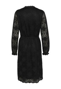 Svart spetsklänning med långa, genomskinliga ärmar och scallopade manschetter. Har ett blommönster, en figursydd midja och en knälång nederkant.