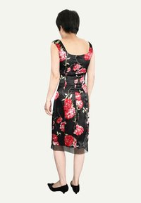 Robe en satin noir avec un motif floral rouge, silhouette ajustée et longueur mi-mollet. Dotée de larges bretelles et d'un détail d'ourlet transparent.
