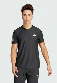Zwart sport T-shirt met korte mouwen, voorzien van witte drie-strepen accenten op de mouwen en een klein logo op de borst. Glad textuur.