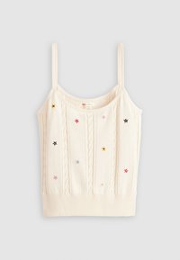 Strikket creme crop top med tynde stropper, der har tekstureret kabelstrik og multifarvet stjernebroderi i forskellige størrelser fordelt over stoffet.
