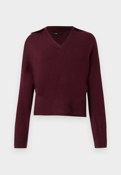 Burgundi kötött pulóver V-nyakkal, crop fazonban és bordázott aljjal. Vállrész kiemelésekkel és hosszú ujjakkal rendelkezik. Puha tapintású.