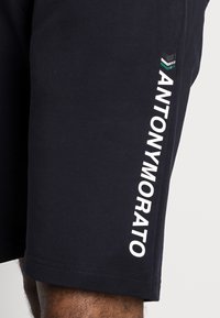Námořnické šortky vyrobené z bavlněné směsi s bílým logem "ANTONYMORATO" potištěným vertikálně po levé straně. Jednoduchý design, regular fit.