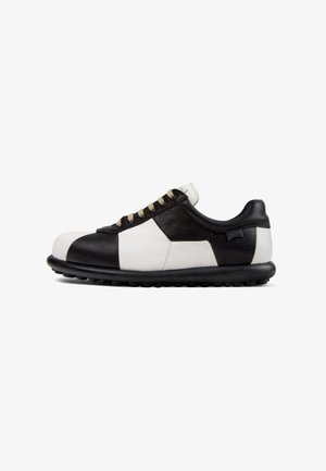 LederSneaker mit einem Schwarz-Weiß-Farbblockdesign, runder Zehenform, flachen Schnürsenkeln und einer schwarzen Gummisohle mit kleinen Noppen.