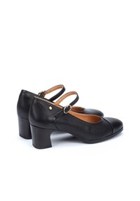 Chaussures à talons noirs avec un bout rond et une finition texturée. Dotées d'une sangle Mary Jane, de matériel doré et d'un talon bloc robuste.