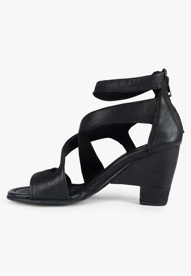 Sandalo con zeppa nera, finitura in pelle testurizzata, punta aperta e cinturini incrociati. Caratterizzato da una chiusura con zip sul tallone posteriore.