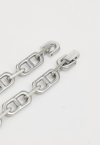 Silberne Metallkette mit rechteckigen Gliedern. Verfügt über einen Verschluss mit eingravierter "BOSS"-Aufschrift. Glatte Oberfläche mit polierter Anmutung.