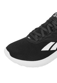 Čierna športová obuv s hornou časťou z textílie sieťoviny, bielou gumovou podrážkou a jemnými akcentmi loga. Dizajn obsahuje textúrované detaily a šnurovacie zapínanie.