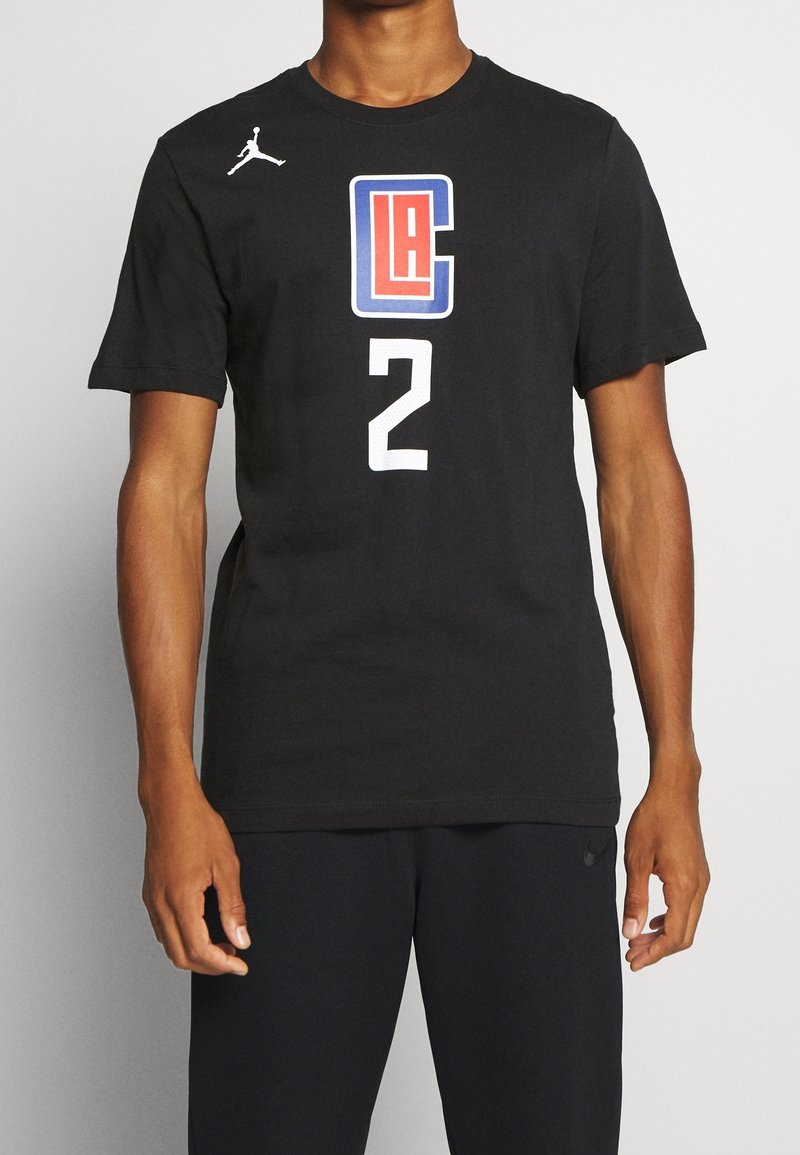 Personne portant un t-shirt noir avec le logo rouge et bleu des LA Clippers, le numéro blanc 2 et un petit logo blanc Jumpman sur la poitrine.