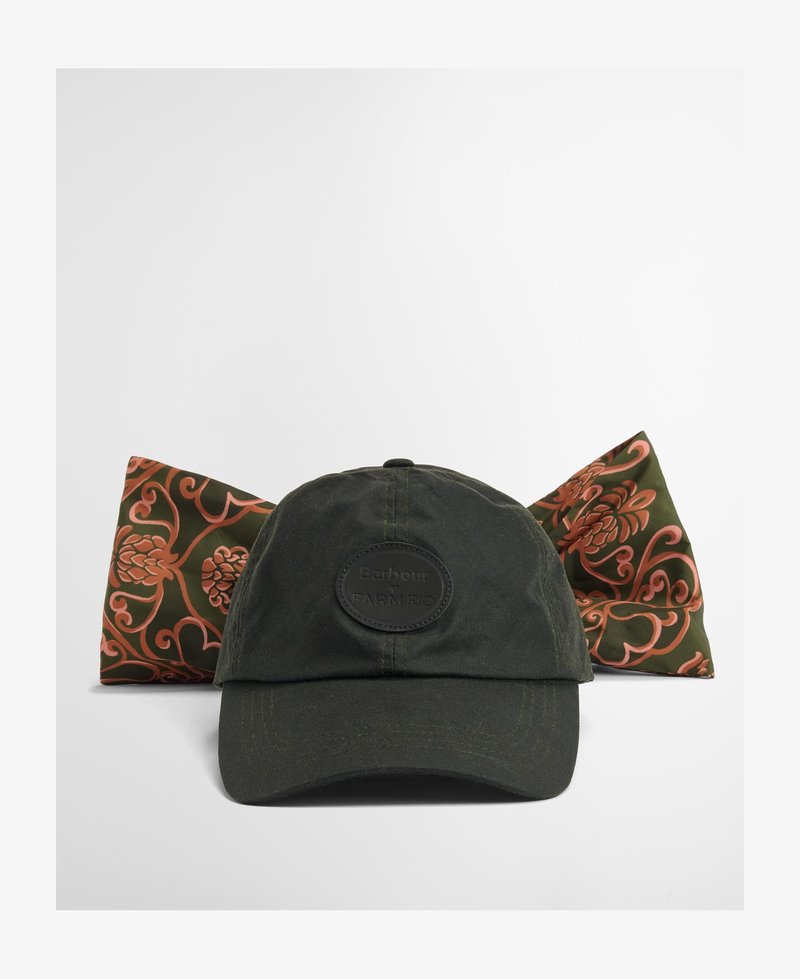 Boné de algodão verde escuro com aba arredondada, apresentando um patch de logotipo circular preto. Um lenço de seda reversível com um padrão floral em coral e verde está atrás.