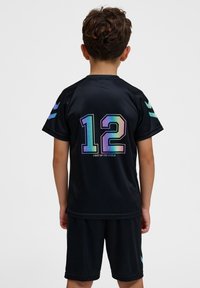 Ensemble de maillot de sport noir avec short, featuring le numéro irisé "12" et le texte "ÉCLAIREZ LE MONDE" au dos, avec des accents turquoise sur les manches.