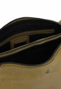 Borsa in pelle verde oliva con chiusura a zip, dotata di un interno in tessuto nero e un piccolo dettaglio logo ancorato in argento.