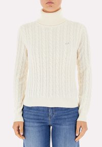 Maglione a collo alto in maglia cable-knit color crema. Presenta polsini e orlo a costine, un motivo tessuto e un piccolo logo sul petto.