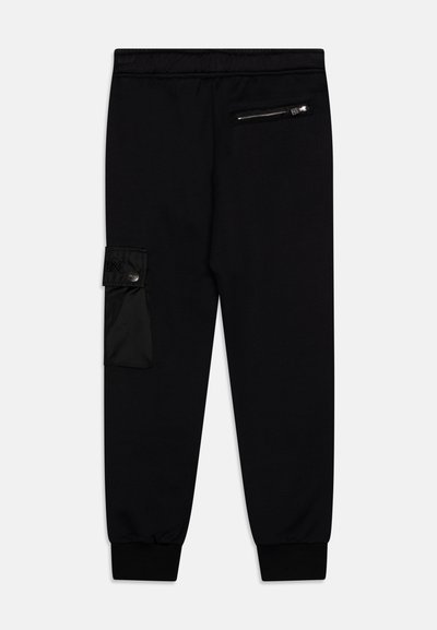 Pantalon de survêtement noir en tissu doux et légèrement texturé. Comprend une poche cargo sur le côté et une poche arrière zippée. Chevilles resserrées.