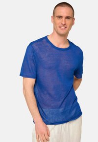 Blue sheer knit T-shirt with a round neckline, short sleeves, and a straight hem. Fabric appears lightweight with visible texture.