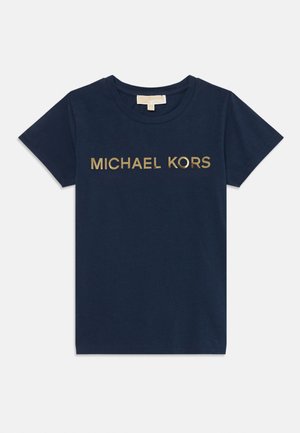 Camiseta de algodón azul marino con mangas cortas y cuello redondo. Presenta un logotipo dorado de "MICHAEL KORS" en el pecho. Textura suave.