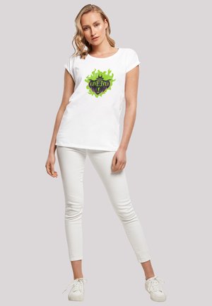 Weißes T-Shirt mit kurzen Ärmeln, das ein Grafikdesign mit grünen Flammen und dem Text "LIVE" zeigt. Kombiniert mit weißen, eng anliegenden Hosen und weißen Sneakern.