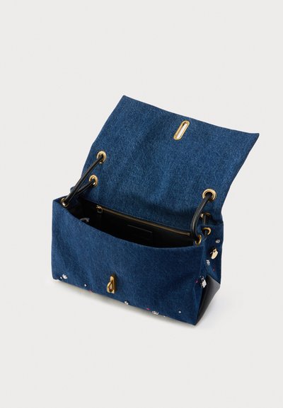 Borsa in denim con finiture dorate, caratterizzata da un interno spazioso e dettagli decorativi sull'esterno. Design con patta aperta e doppie cinghie.