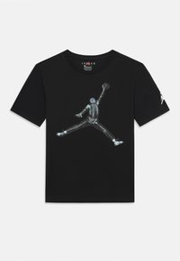Čierne tričko s grafickým potlačením kostlivca, ktorý dunkuje basketbal. Má okrúhly výstrih a krátke rukávy. Logo Jordan na rukáve.