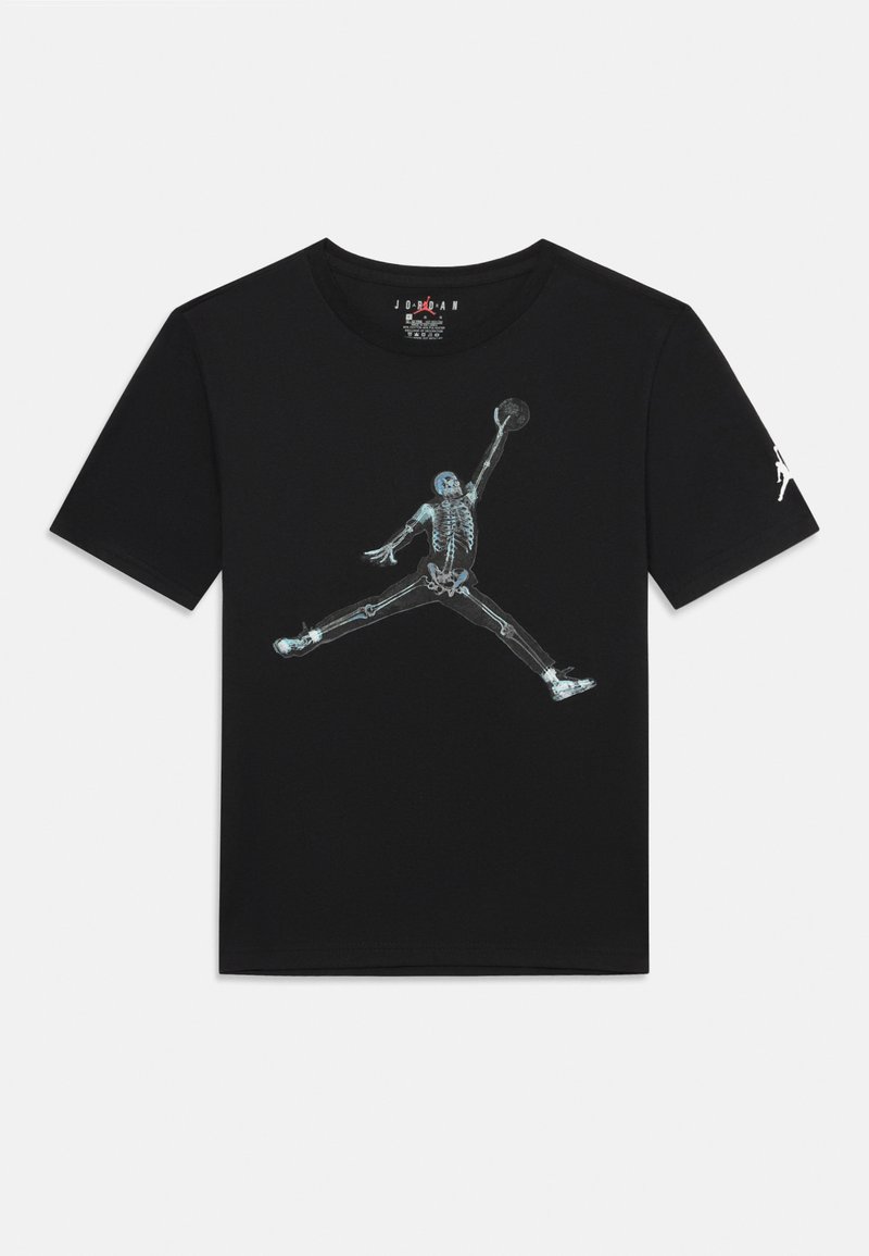 Čierne tričko s grafickým potlačením kostlivca, ktorý dunkuje basketbal. Má okrúhly výstrih a krátke rukávy. Logo Jordan na rukáve.