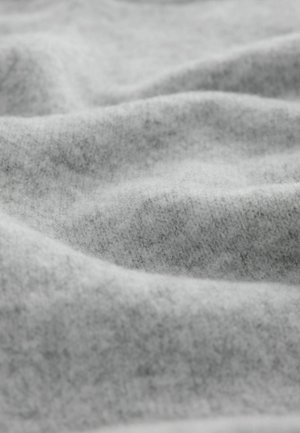 Hallidekootud kude pehme ja tekstuurse pinnaga, kust nähtuvad õrnad voldid ja peen heatheri muster.