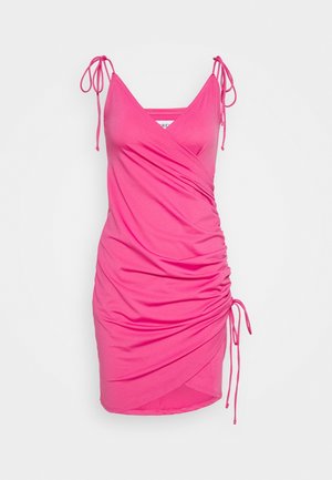 Robe sans manches rose avec des bretelles réglables, détails froncés sur le côté et design croisé. Fabriquée en matériau lisse et extensible.