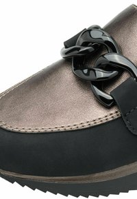 Baskets noires et en bronze métallique avec un design épuré, une tige lisse, une semelle épaisse et un accent en chaîne noire proéminent.