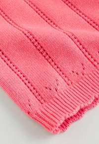 Kötött pulóver élénk rózsaszínben, bordázott szegéllyel. F vertikális texturált csíkokkal és átfont szövésekkel, amelyek elosztva találhatók az anyagon.