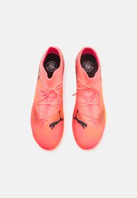 Zapatillas deportivas de un brillante color rosa, con una parte superior de punto texturizado, acentos de logo en negro y diseño de cordones. Forma ligera y aerodinámica.