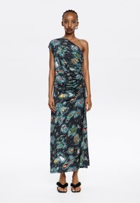 One-shoulder maxi dress in lightweight, patterned fabric featuring aquatic animals in vibrant colors on a dark background, with ruched detail.