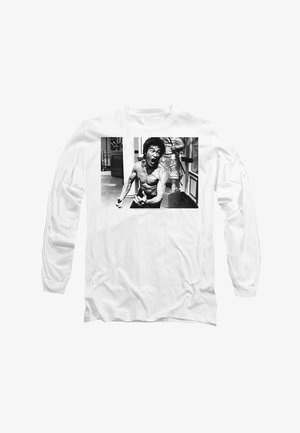 Weißes, langärmeliges T-Shirt mit einem schwarz-weiß Grafikdruck eines muskulösen Mannes in einer ausdrucksstarken Pose, aus strukturiertem Stoff.